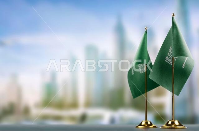 Small flags of the Saudi Arabia on an abstract blurry background