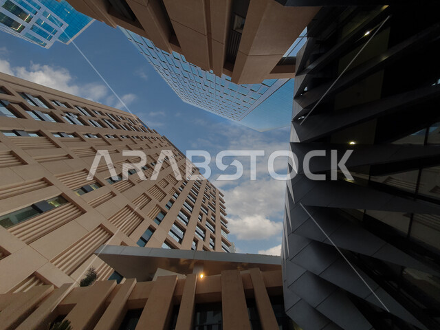 صورة ابداعية بزاوية سفلية لمركز الملك عبدالله المالي ( كافد ) في الرياض بالمملكة العربية السعودية، الأبراج وناطحات السحاب، معالم الرياض المشهورة، الفن الهندسي المعماري بالسعودية، السياحة في السعودية