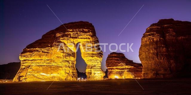 Illuminated sandstone elephant rock erosion monolith standing in the night desert, Al Ula, Saudi Arabia