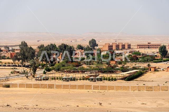A small town in the middle of the desert surrounded by a high fence