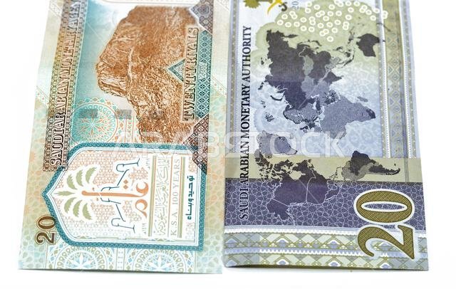 ٢٠ ريالاً سعودياً، عملة ورقية قديمة عليها صورة الملك عبد العزيز ومسجد قباء وجبل النور، وعملة جديدة عليها صورة الملك