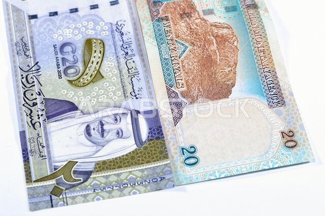 ٢٠ ريالاً سعودياً، عملة ورقية قديمة عليها صورة الملك عبد العزيز ومسجد قباء وجبل النور، وعملة جديدة عليها صورة الملك