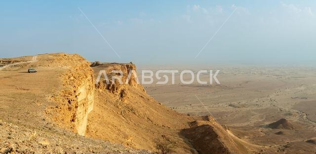 سيارة على حافة جبال جبل طويق، مع منظر طبيعي صحراوي، الرياض، المملكة العربية السعودية