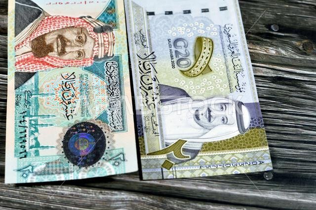 ٢٠ ريالاً سعودياً، عملة ورقية قديمة عليها صورة الملك عبد العزيز ومسجد قباء وجبل النور، وعملة جديدة عليها صورة الملك