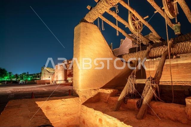 Diriyah old town well with highlighted wall in the background at night, Riyadh, Saudi Arabia