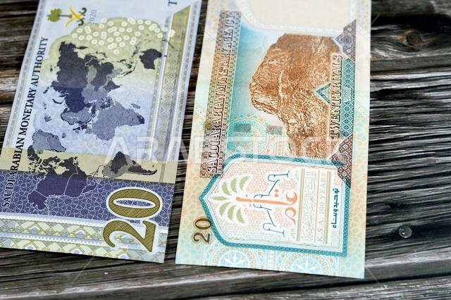 ٢٠ ريالاً سعودياً، عملة ورقية قديمة عليها صورة الملك عبد العزيز ومسجد قباء وجبل النور، وعملة جديدة عليها صورة الملك