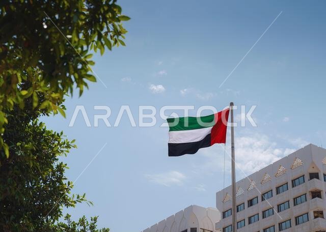 يرفرف علم دولة الإمارات العربية المتحدة في السماء. تحتفل الإمارات بيومها الوطني في الثاني من ديسمبر من كل عام.