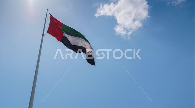 United Arab Emirates flag flying against sky. UAE celebrates it's national day on 2nd December every year.