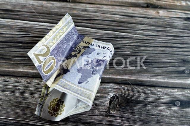 عملة سعودية مجعدة من فئة 20 ريالاً سعودياً عليها شعار قمة مجموعة العشرين، وصورة الملك سلمان، وخريطة العالم، وأوراق نقدية مجعدة، وعملة سعودية في