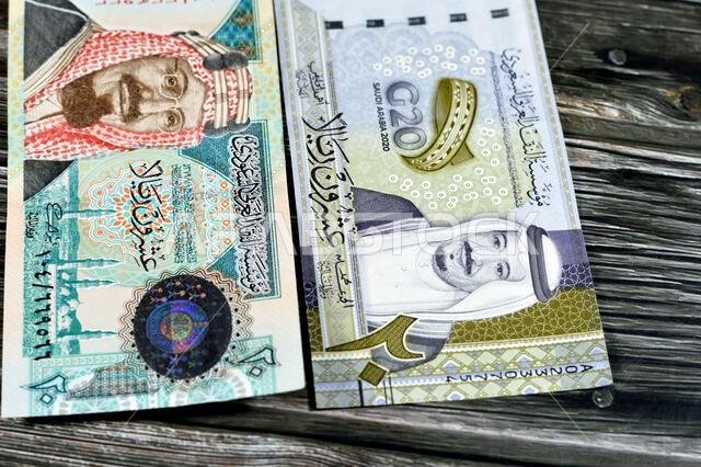 ٢٠ ريالاً سعودياً، عملة ورقية قديمة عليها صورة الملك عبد العزيز ومسجد قباء وجبل النور، وعملة جديدة عليها صورة الملك