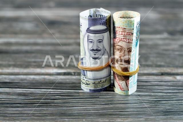 ٢٠ ريالًا سعوديًا، أوراق نقدية ملفوفة بأربطة مطاطية، تحمل صور الملك سلمان و...