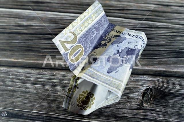 Crumpled Saudi Arabia money of 20 SAR twenty riyals with G20 summit logo, photo of king Salman, world map, wrinkled cash bill banknote, Saudi money in