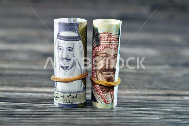 ٢٠ ريالًا سعوديًا، أوراق نقدية ملفوفة بأربطة مطاطية، تحمل صور الملك سلمان و...