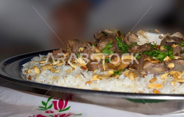 لحم الإبل مع الأرز، طبق رئيسي من المطبخ العربي التقليدي، يُقدم كغداء في مطعم مع اللوز وبذور الصنوبر. لحم الإبل مع الأرز، طبق رئيسي من المطبخ العربي التقليدي، يُقدم كغداء في مطعم مع اللوز وبذور الصنوبر.