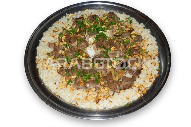 لحم الإبل مع الأرز، طبق رئيسي من المطبخ العربي التقليدي، يُقدم كغداء في مطعم مع اللوز وبذور الصنوبر.