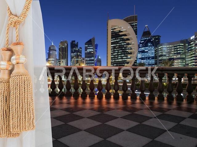 A view of Doha city, Qatar from a terrace (balcony) of a high building from inside the room showing a white beautiful curtains.