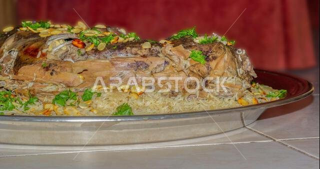 الأوزي العربي (لحم ضأن محشو بالأرز). نوع من الأطعمة العربية التقليدية. مزين باللوز والمكسرات والبقدونس.
