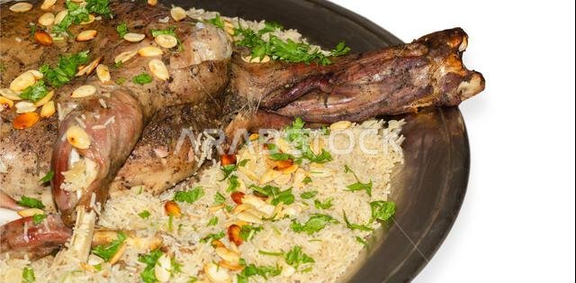 الأوزي العربي (لحم ضأن محشو بالأرز). نوع من الأطعمة العربية التقليدية. مزين باللوز والمكسرات والبقدونس.