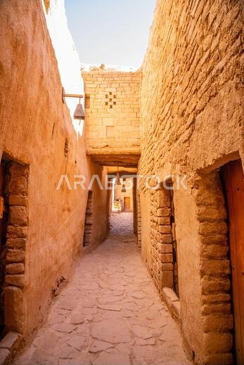 شارع البلدة القديمة في العلا بين جدران من الطوب اللبن، المملكة العربية السعودية