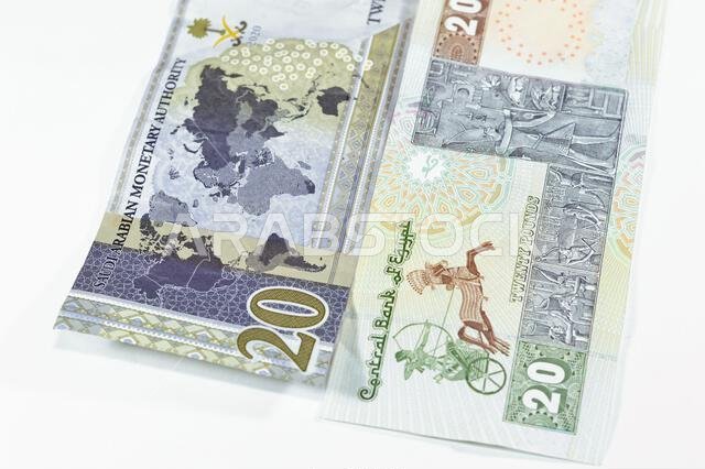 ورقة نقدية سعودية من فئة 20 ريالاً سعودياً، مع 20 جنيهاً مصرياً، وسعر صرف العملات المصرية والسعودية، وصورة لمسجد محمد علي.