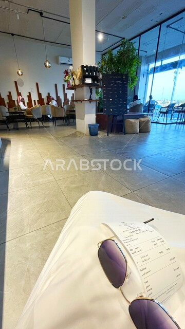 صورة داخل أحد المقاهي بالمملكة العربية السعودية , نظارة شمسية , اكسسوارات رجالية , فاتورة انتظار الطلب داخل المقهى .