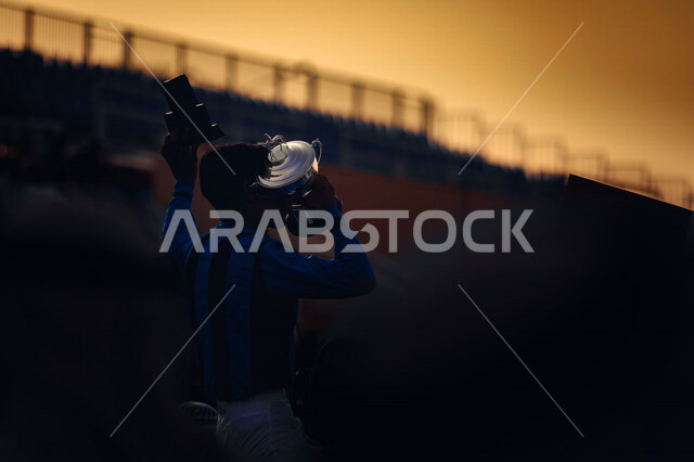 شاب عربي سعودي خليجي يحمل كأس الفوز بالمباراه, المنافسه والفوز, انديه وتشجيع, الفوز في مباريات كأس العالم