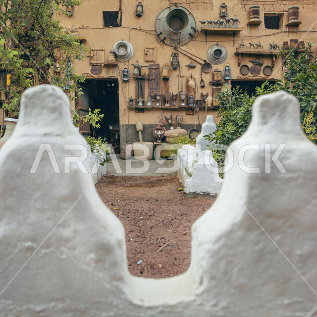  متحف شعبي للتراث التقليدي القديم, حائط طيني عليه أدوات و مشغولات يدوية قديمة معلقة ، الحياة البدوية في القرى السعودية ، معالم سياحية في المملكة العربية السعودية