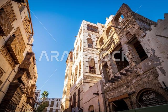 Exterior view of a dilapidated traditional residential town house next to a recently renovated building, Al-Balad, Jeddah, KSA, Saudi Arabia