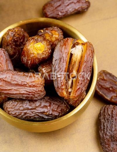 تمر مجدول عضوي خام (يُعرف باسم "كورما" في إندونيسيا). إنه أيضاً وقت إفطار رمضان. رمضان كريم. منظر علوي. مساحة لإضافة نص.