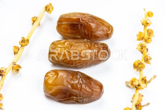صورة مقرّبة لتمور جزائرية ملكية على خلفية بيضاء. مفهوم رمضان.