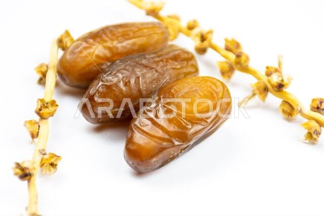 صورة مقرّبة لتمور جزائرية ملكية على خلفية بيضاء. مفهوم رمضان.