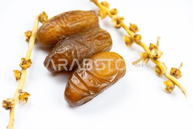 صورة مقرّبة لتمور جزائرية ملكية على خلفية بيضاء. مفهوم رمضان.