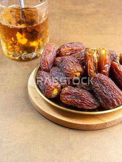تمر مجدول عضوي خام (يُعرف باسم "كورما" في إندونيسيا). إنه أيضاً وقت إفطار رمضان. رمضان كريم. منظر علوي. مساحة لإضافة نص.