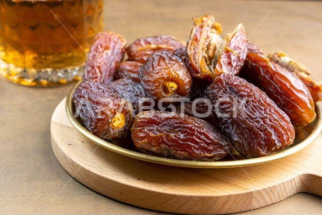 تمر مجدول عضوي خام (يُعرف باسم "كورما" في إندونيسيا). إنه أيضاً وقت إفطار رمضان. رمضان كريم. منظر علوي. مساحة لإضافة نص.