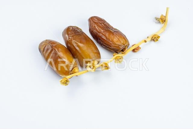 Close-up of Algerian royal dates on a white background. Ramadan concept. Close-up of Algerian royal dates on a white background. Ramadan concept.