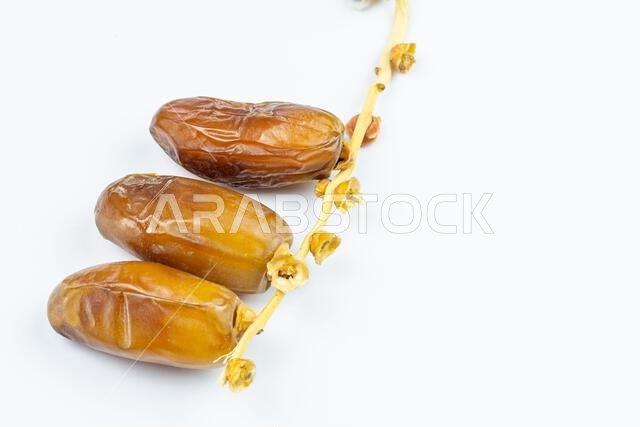 صورة مقرّبة لتمور جزائرية ملكية على خلفية بيضاء. مفهوم رمضان.