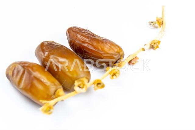 صورة مقرّبة لتمور جزائرية ملكية على خلفية بيضاء. مفهوم رمضان.