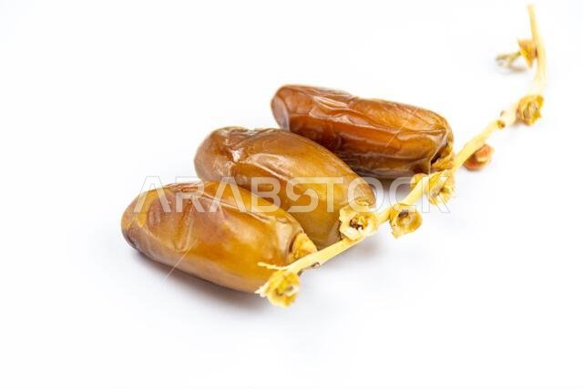 صورة مقرّبة لتمور جزائرية ملكية على خلفية بيضاء. مفهوم رمضان.