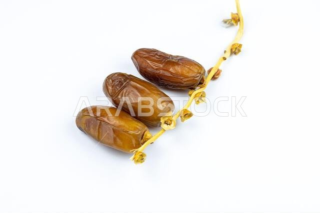 صورة مقرّبة لتمور جزائرية ملكية على خلفية بيضاء. مفهوم رمضان.
