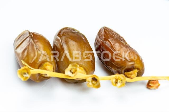 صورة مقرّبة لتمور جزائرية ملكية على خلفية بيضاء. مفهوم رمضان.