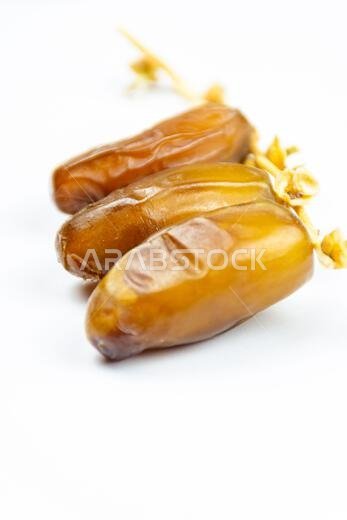 صورة مقرّبة لتمور جزائرية ملكية على خلفية بيضاء. مفهوم رمضان.
