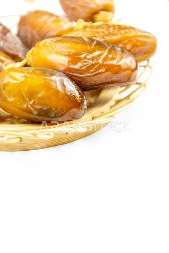 Close-up of Algerian royal dates on a wooden plate on a white background. Ramadan concept.