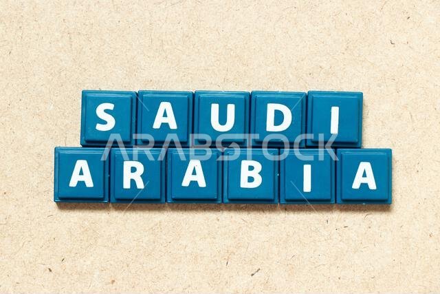 Tile alphabet letter in word saudi arabia on wood background