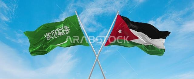 علمان متقاطعان، علم الأردن وعلم السعودية، يرفرفان في مهب الريح تحت سماء ملبدة بالغيوم. يرمز هذا العمل الفني إلى مفهوم العلاقة والحوار والسفر بين البلدين. رسم ثلاثي الأبعاد.