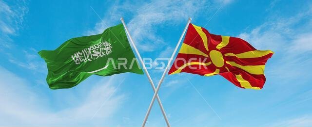 علمان متقاطعان، علم مقدونيا وعلم السعودية، يرفرفان في مهب الريح تحت سماء ملبدة بالغيوم. يرمزان إلى العلاقة والحوار والسفر بين البلدين. رسم توضيحي ثلاثي الأبعاد