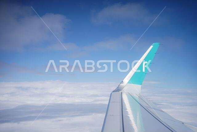 Airplane wing background ,FlyNas logo airline on the airplane wing. view of an airplane wing on the sky from the airplane window in the morning with c