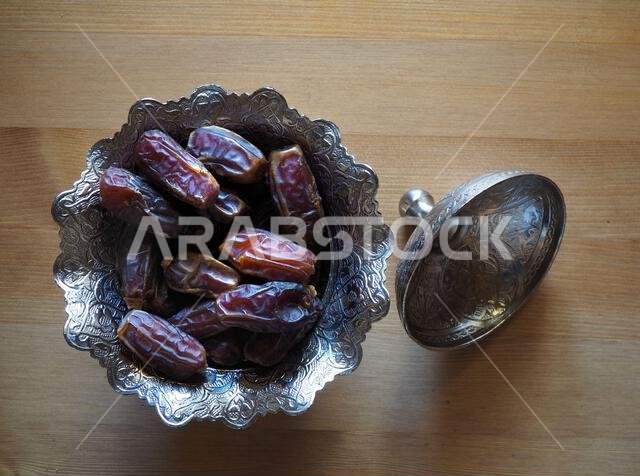 Dried date fruit. Traditional Ramadzan food for Muslims. Ramadan Kareem background or banner. Dried dates on wooden background.