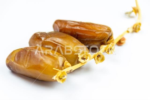 صورة مقرّبة لتمور جزائرية ملكية على خلفية بيضاء. مفهوم رمضان.