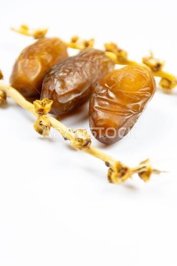 صورة مقرّبة لتمور جزائرية ملكية على خلفية بيضاء. مفهوم رمضان.