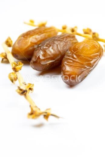 صورة مقرّبة لتمور جزائرية ملكية على خلفية بيضاء. مفهوم رمضان.